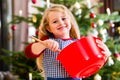 Girl baking cookies in front of Christmas tree Royalty Free Stock Photo