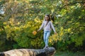 A girl balances on a fallen log with a leaf in her hand Royalty Free Stock Photo