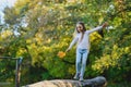 A girl balances on a fallen log with a leaf in her hand Royalty Free Stock Photo