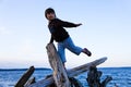 Girl Balancing on Driftwood at the Beach