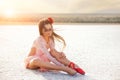 Girl ballerina dancer in a pink dress on a snow-white salty dried lake. Fantastic landscape and a girl in red punata and a pink dr