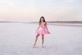 Girl ballerina dancer in a pink dress on a snow-white salty dried lake. Fantastic landscape and a girl in red punata and a pink dr Royalty Free Stock Photo