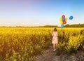 Girl with balloons in blooming field Royalty Free Stock Photo