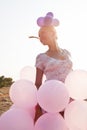 Girl with balloons by the rays of sunlight