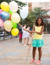 Girl with balloons standing outdoors