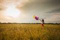 Girl with balloons in wheat field Royalty Free Stock Photo