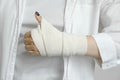 A girl with a bandaged hand shows a thumbs up, a hand injury, an elastic bandage, first aid to the patient Royalty Free Stock Photo