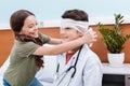 girl bandaging boy doctor's head in hospital