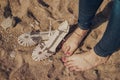 Girl barefoot in jeans on sand with barefooted