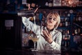 Girl barman makes a cocktail on the saloon