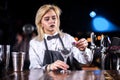 Girl barman creates a cocktail in the bar