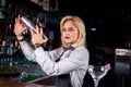 Girl barman mixes a cocktail in the beerhouse