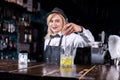 Girl barman makes a cocktail at the taproom