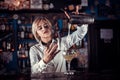 Girl barman makes a cocktail on the saloon