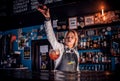 Girl barman mixes a cocktail in the bar