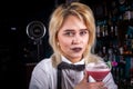 Girl barman concocts a cocktail behind the bar