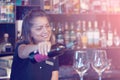 Girl bartender pours wine into a wine glass Royalty Free Stock Photo