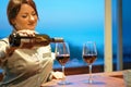 Girl bartender pours wine into a wine glass Royalty Free Stock Photo