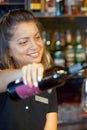 Girl bartender pours wine into a wine glass Royalty Free Stock Photo