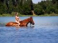 Girl bathe horse in the lake.