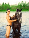 Girl bathe horse in a river