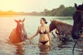 Girl bathe horse in a river.