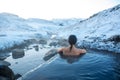 The girl bathes in a hot spring in the open air with a gorgeous view of the snowy mountains. Incredible iceland in winter Royalty Free Stock Photo