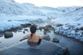 The girl bathes in a hot spring in the open air with a gorgeous view of the snowy mountains. Incredible iceland in winter Royalty Free Stock Photo