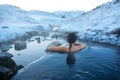 The girl bathes in a hot spring in the open air with a gorgeous view of the snowy mountains. Incredible iceland in winter Royalty Free Stock Photo