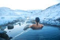 The girl bathes in a hot spring in the open air with a gorgeous view of the snowy mountains. Incredible iceland in winter Royalty Free Stock Photo