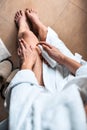 The girl in the bathroom puts anti-cellulite cream, serum on the legs and body. Body care concept. Top View Royalty Free Stock Photo