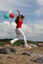 Girl on beach with balloons Royalty Free Stock Photo