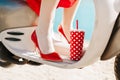 Girl on the beach with a cocktail. Female legs in a red skirt . 60s pin-up style Royalty Free Stock Photo