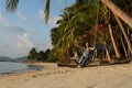 The girl on the beach rides on a swing during sunset. Sunset in the tropics, enjoying nature. Swing tied to a palm tree by the Royalty Free Stock Photo