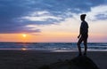 Girl on the beach at sunset with sun over the sea Royalty Free Stock Photo