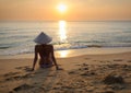 girl on beach at sunset wearing a rice hat 1