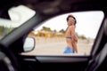 Girl on a beach teasing through car window Royalty Free Stock Photo
