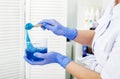 Girl beautician holds blue sugar paste for epilation on a spatula in a beauty salon. Close-up. Spatula and epilation paste in hand Royalty Free Stock Photo