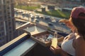 A girl with a beautiful breast in a sports suit eats pizza and drinks mojito on the sunset city background