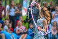 Girl in beautiful dress performs with hula hoops