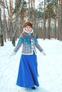 A girl with beautiful hair on her head in a Slavic style in full growth in the winter forest