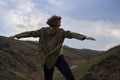 Girl on beautiful mountain view feeling free with wind and sky. Isolated woman on nature background, freedom, post apocalyps Royalty Free Stock Photo