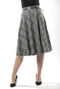 girl with beautiful slender legs in a long wool skirt on a white background, long gray plaid skirt Royalty Free Stock Photo