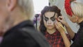 Easy Halloween Makeup. Girl in a beauty salon. Applying a stylistic pattern on the face of the model. The work of a master stylist