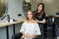 A girl in a beauty salon, a hairdresser does her hair, cuts her hair to a girl with long hair. a woman dyes her hair Royalty Free Stock Photo