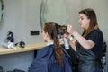 A girl in a beauty salon, a hairdresser does her hair, cuts her hair to a girl with long hair Royalty Free Stock Photo