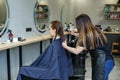 A girl in a beauty salon, a hairdresser does her hair, cuts her hair to a girl with long hair. a woman dyes her hair Royalty Free Stock Photo