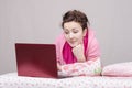 Girl in bed with interest works for laptop Royalty Free Stock Photo