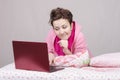 Girl on bed looking with interest at laptop Royalty Free Stock Photo