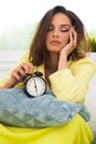 Girl in bed in morning with retro clock